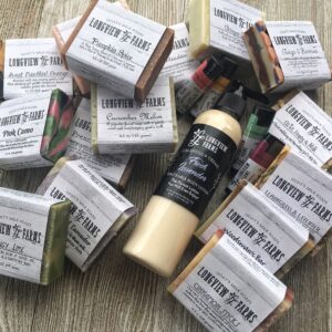 Handmade soaps and lotion arranged on a wooden surface.
