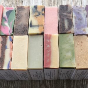 Rows of assorted handmade soap bars in various colors and patterns.