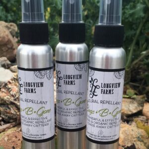 Three bottles of Lovegunz Home Repellent displayed outdoors.
