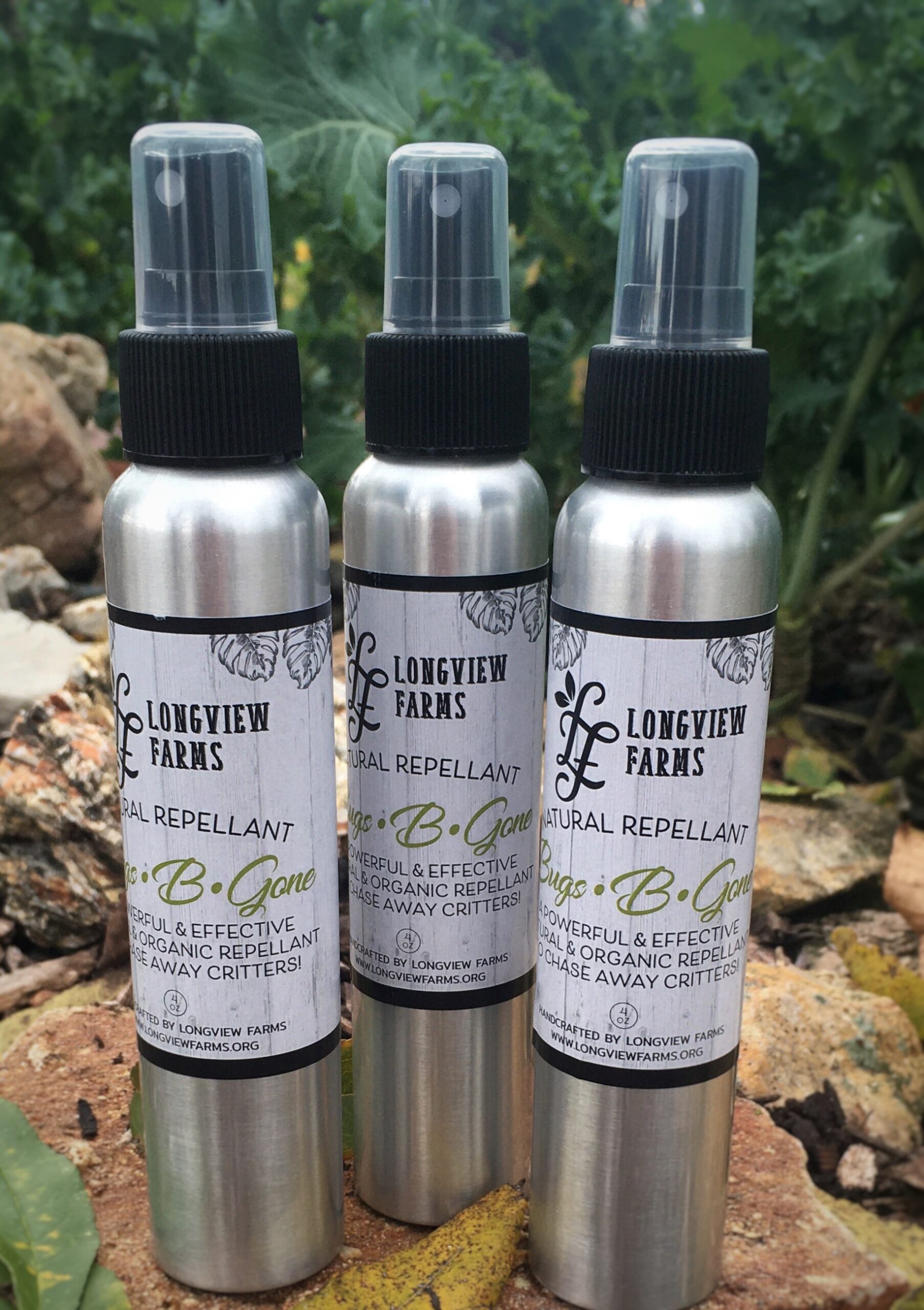 Three bottles of Lovegunz Home Repellent displayed outdoors.