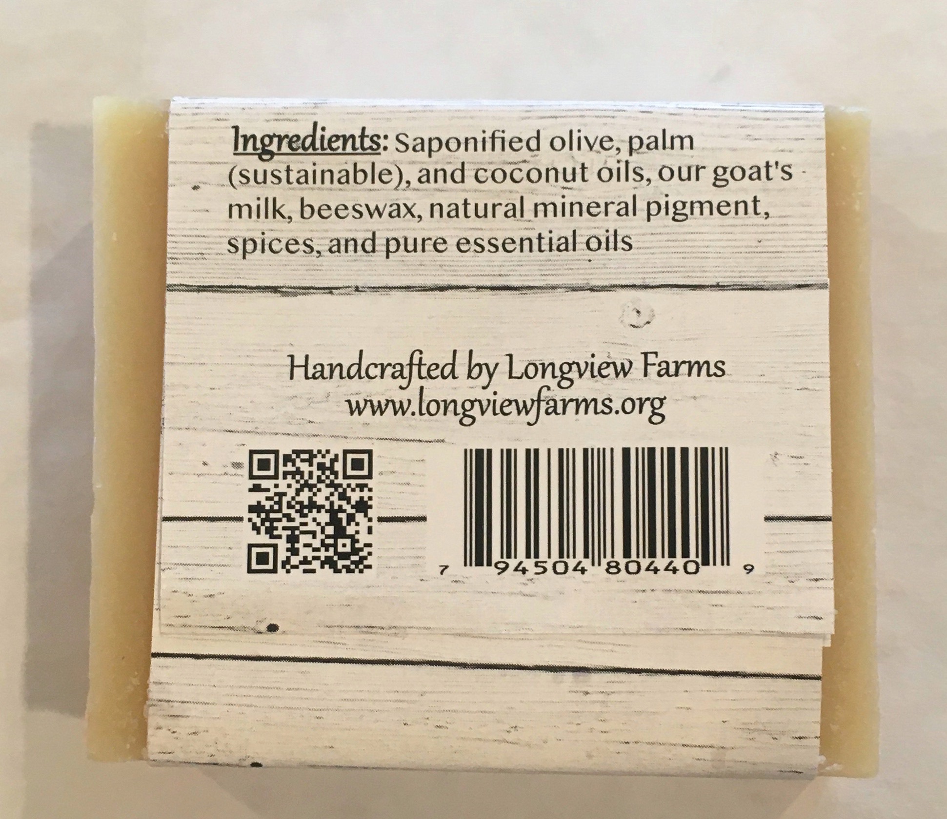Bar of handcrafted soap with a detailed ingredient list and farm information.