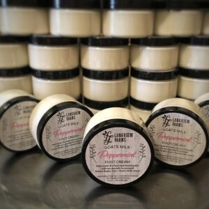 Stack of skin moisturizer jars labeled 100% natural and fragrance-free.