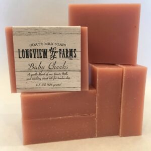 Handmade rosy-colored soap bars stacked with a vintage label.