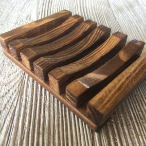 Handcrafted wooden soap dish with grooves for drainage.