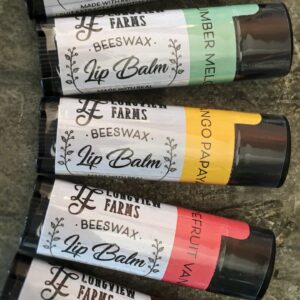 Various flavored lip balms from JC Farms displayed on a surface.